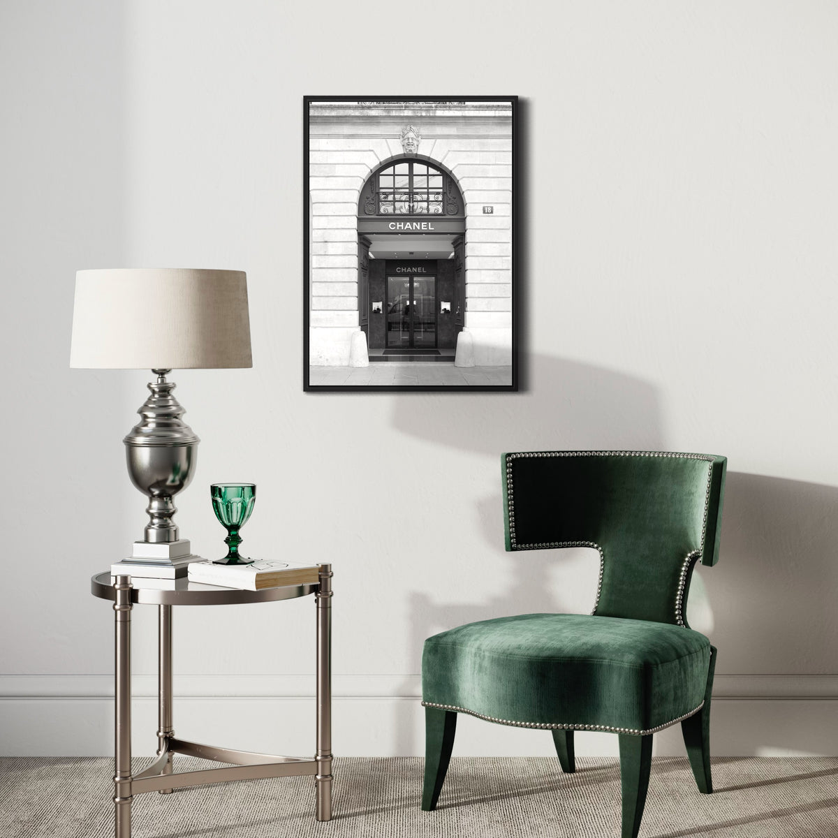 Modern living room with stylish velvet chair, round side table, lamp, and framed black and white poster on wall