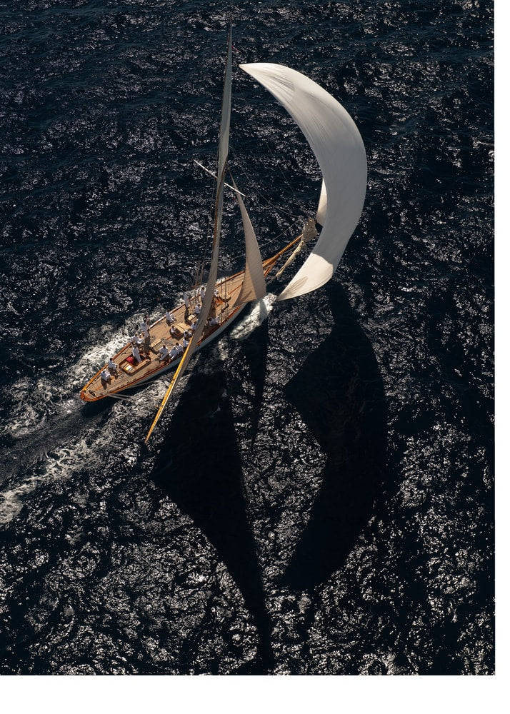 Aerial spinnaker sailboat poster with a wooden sailboat and large white spinnaker on dark water
