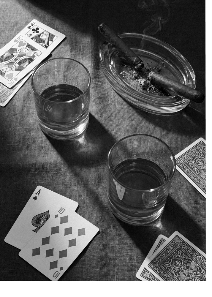 Cards and cigars poster with a black and white still life of playing cards, glasses and cigars
