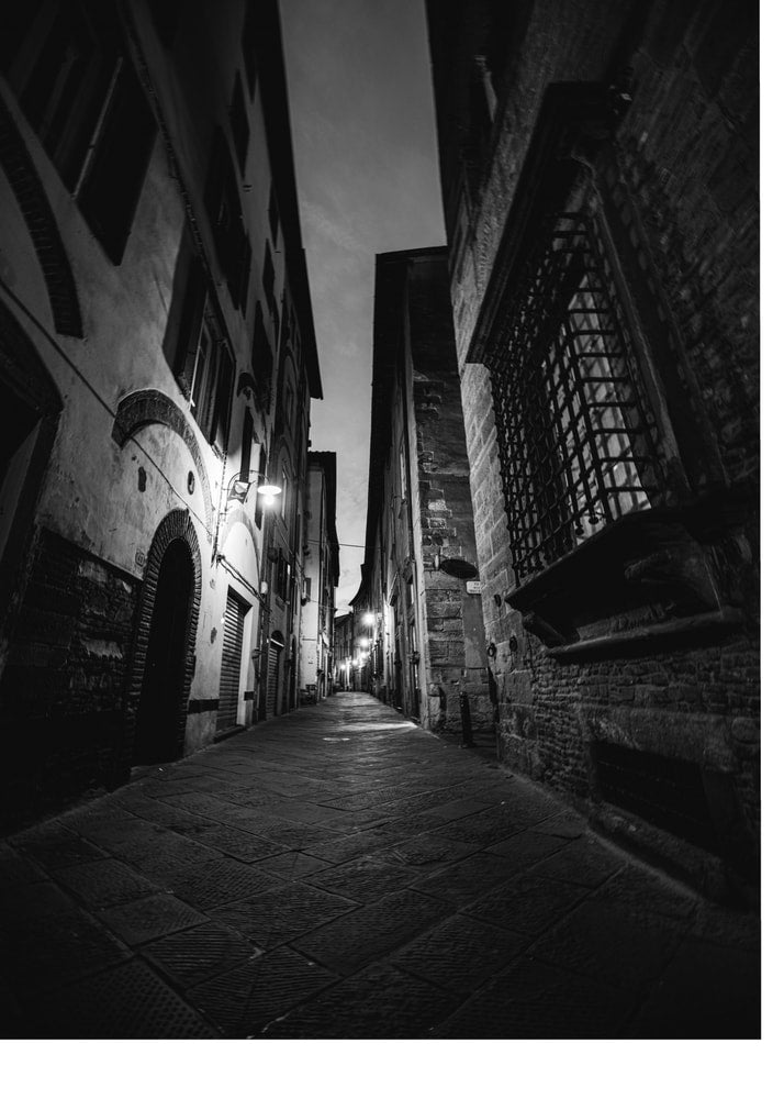Cobblestone alley poster with a black and white view of a narrow alley between old buildings