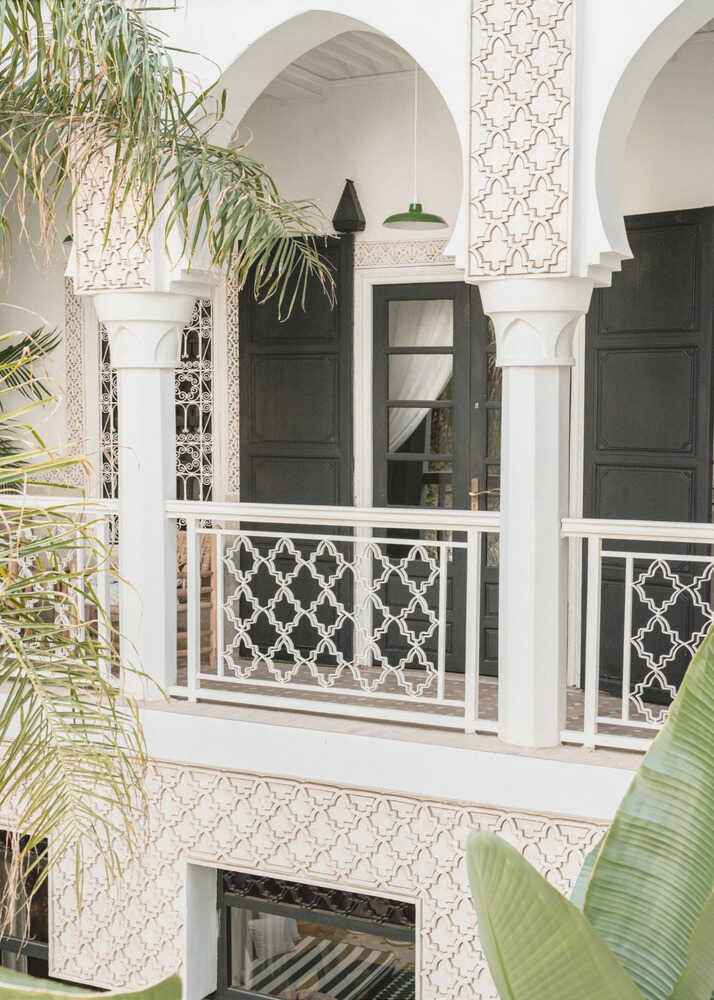 Moroccan balcony poster with a white balcony with arches black doors and geometric lattice