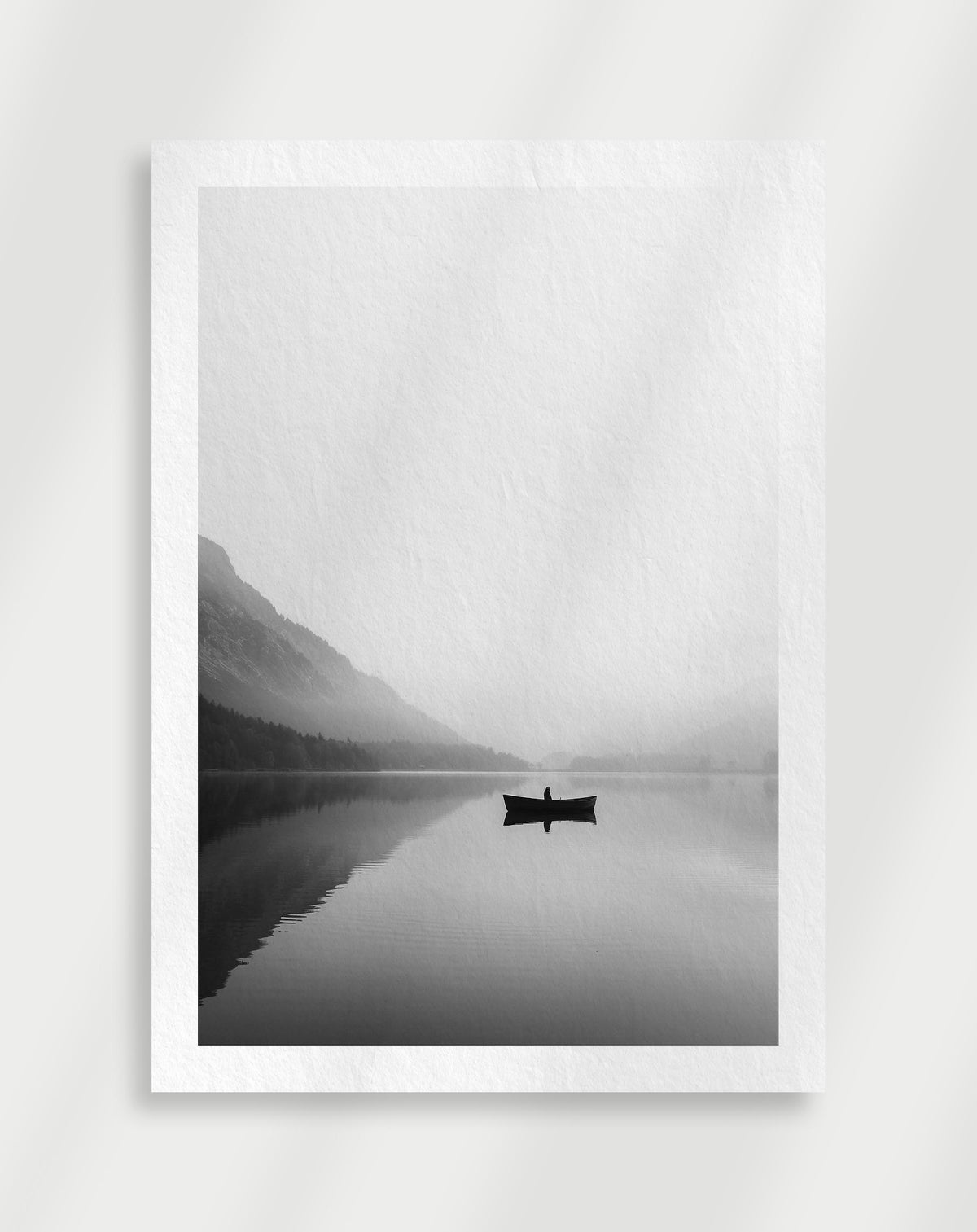Mountain lake boat poster with a black and white view of a small boat on a lake with mountains