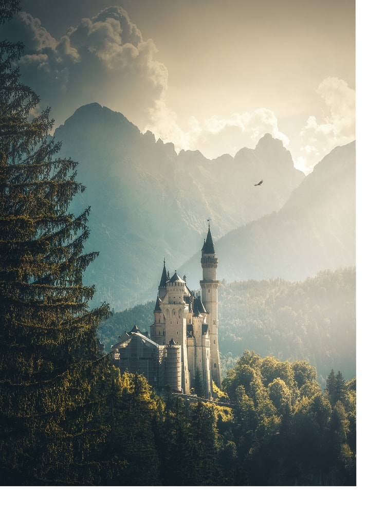 Neuschwanstein Castle poster with the castle in a forest and mountains under golden light
