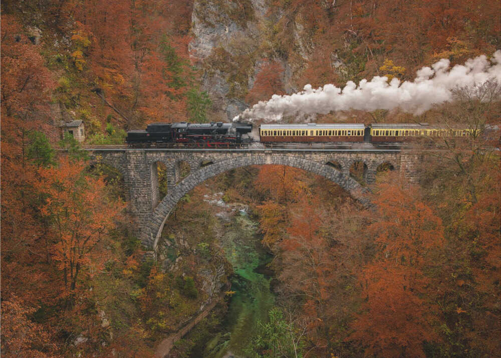 Steam train viaduct poster with a steam train crossing a stone viaduct in autumn forest